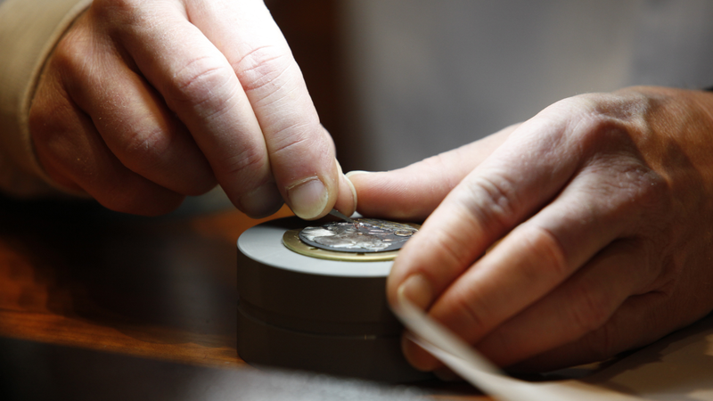 A watchmaker works on a wrist watch. If this doesn’t make sense to you, you haven’t listened to the podcast.